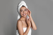 © New Africa - Beautiful young woman with towels on grey background