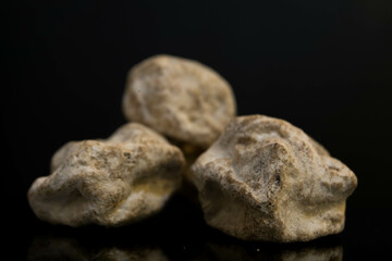 selective focus Salty Chinese plums with dark background and lighting. look like stone or rock.