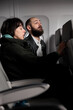 © DC Studio - Man and woman travelling on vacation by airplane transport, waiting to takeoff on commercial flight in economy class, going to voyage destination. International airways on aerial transportation.
