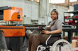 © AnnaStills - Portrait of African worker sitting in wheelchair with remote control to control the operation of machine at factory