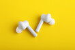 © Niks Ads - Technology concept : wireless headphone or ear bud on yellow background.