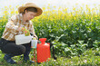 Woman pours liquid mineral fertilizer. Cultivation and caring.