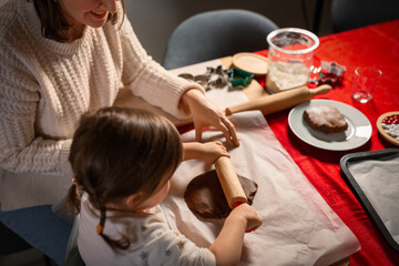 Poster - family, cooking and winter holidays concept - happy mother and baby daughter with rolling pin making gingerbread cookies from dough at home on christmas