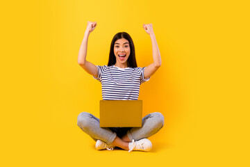 Full body portrait of filipino lady raise fists celebrate success achievement isolated on yellow color background