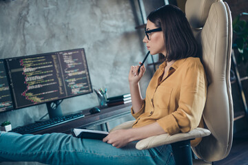 Profile photo of minded focused web designer sitting chair hold pen touch chin look screen workstation office