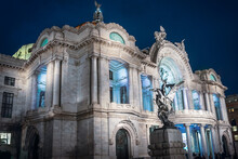 Side View Of The Palace Of Fine Arts (Palacio De Bellas Artes) Beautifully Illuminated At Night - Dramatic Marble Performance Hall, Exhibition Venue, Museum And Theatre In Mexico City, Mexico.