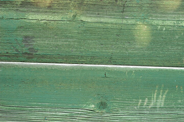 wooden green background, house wall, panel in sunlight