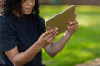 © Austockphoto - teenager outside on grass holding digital tablet