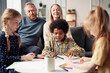 © AnnaStills - Group of children drawing pictures at table for their parents during leisure time at home
