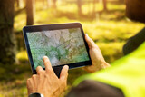Fototapeta  - surveyor working with forest topography map in digital tablet. land surveying