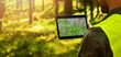 © ronstik - man working with topographic map data on digital tablet in forest. banner with copy space