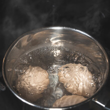 Close-up With Boiling Eggs In A Metal Pan, Bubbles And Steam When Boiling Water With Chicken Eggs. Quick Breakfast
