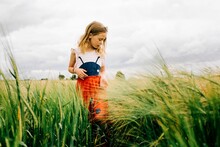 Young Girl Walking Through A Corn Field In A Bug Dress