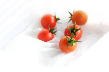 Blurry a group of small tomatoes on s white tissue 