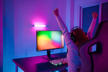 A Professional female pro gamer play online video games cyber sport and esport winner emotion. Young woman in tournament match worldwide in room colorful neon lights.