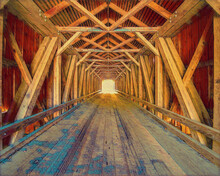 The Painted Image Inside Lowe's Covered Bridge In Maine, With Light At The End.