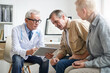 © Mediaphotos - Serious senior male doctor in white coat using digital tablet while analyzing tests results of aged patients after medical checkups