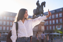 Happy Caucasian Woman Is Taking A Selfie Smiling At The Camera In Front Of The Equestrian Monument To King Felipe III Of Spain In The Plaza Mayor In Madrid