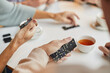 © Mediaphotos - Close-up of elderly woman sitting at table and holding domino pieces in hand, she participating in domino tournament in retirement home