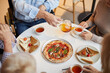 © Mediaphotos - Above view of unrecognizable senior friends sitting at table and drinking tea with snacks at tea party