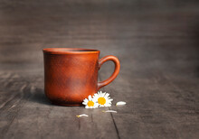 Earthenware Mug With Chamomile Flowers Close-up On A Black Background