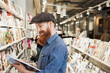 © FOLIO - Bearded man reading magazine in store