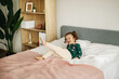 © Sviatlana - An emotional little girl is playing on the bed in the bedroom and laughing