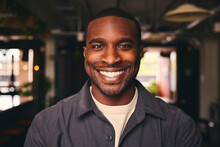 Smiling Young Black Male Standing In Office Looking At Camera