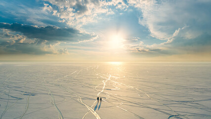 The two people walking through the endless snow field