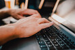 © pavel siamionov - close up shot of a young mans hands typing something on a gray laptop