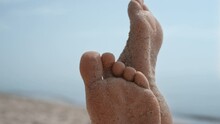 Bare Woman Feet Smeared With Beach Sand Close Up. Barefoot Girl Raising Up Legs.
