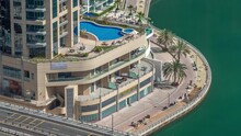 Dubai Marina Waterfront And City Promenade With Swimming Pool Timelapse From Above. Aerial View To Skyscrapers Along The Canals. Construction Workers Making A Tile Walkway