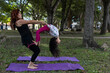 © Amilciar - Latin American mom and daughter have fun in the park doing yoga and exercise together