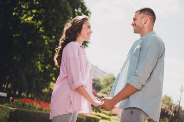 Sticker - Profile portrait of two idyllic cheerful partners hold arms look each other enjoy good mood date outside