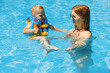 © Shopping King Louie - mother and her little son an adorable laughing boy having fun together in an outdoor swimming pool on a hot summer day