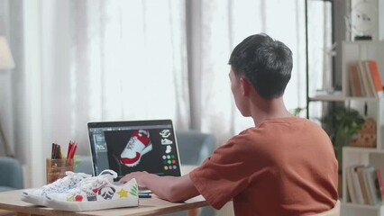 Asian Boy Footwear Designer Having A Headache While Designing Shoe On A Laptop At Home. Shoe Production Procedure Concept 
