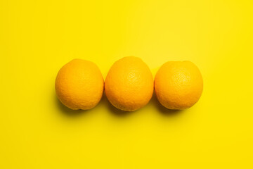 Canvas Print - Top view of natural oranges on yellow background.