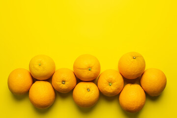 Wall Mural - Flat lay with organic oranges with shadow on yellow background.