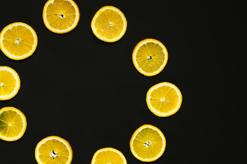 Wall Mural - Flat lay with frame from slices of oranges isolated on black.