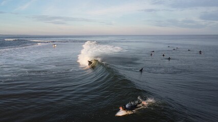 Sticker - Beautiful view of a sea with waves and surfers under the clear sky