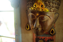 Wooden Buddha Mask Hanging On A Wall