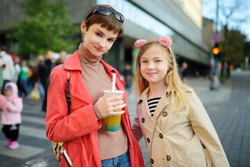 Wall Mural - Two cute young sisters having fun together on beautiful autumn day. Active family leisure with kids.