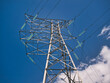 An electricity supply pylon delivering power through the UK national grid showing power cables, isolators and other equipment. This is an angle tower that allows the cables to change direction.