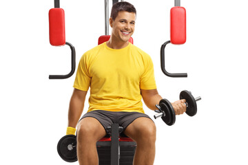 Sticker - Young man exercising with weights on a fitness machine and looking at camera