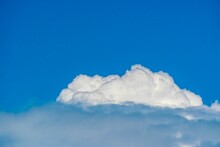 A Heavy White Lone Cumulus Cloud Against A Blue Summer Sky.