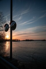 Sticker - A sunset in summer landscape, lake surrounded by trees, reflection of sun on surface of the water