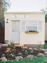 Tiny Shed With Blue Door, Shutters, And Garden