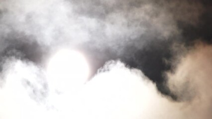 Wall Mural - bright glowing orb and back lit clouds float through black sky, real time.
