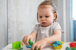 © Miljan Živković - One girl small caucasian toddler child playing with colorful plasticine on the table at home alone childhood and growing up development concept copy space
