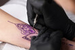 © New Africa - Professional artist making tattoo on hand at table, closeup